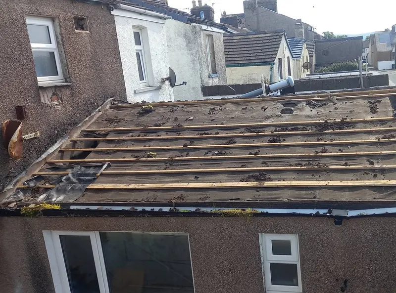 Extension roof with the old tiles removed, showing the old felt and timber battens